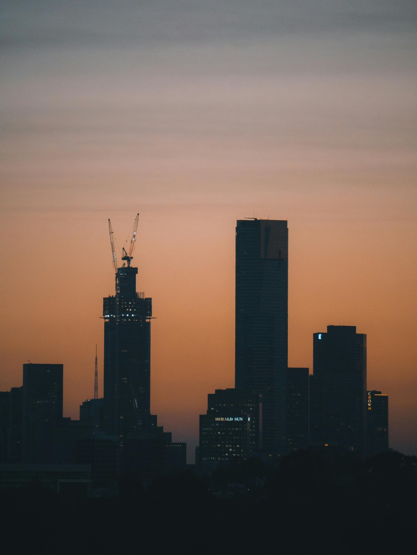 Silhouette of Melbourne skyscrapers against a vibrant sunset sky