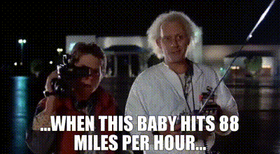 Doc Brown and Marty McFly beside the DeLorean in Back to the Future, captioned when this baby hits 88 miles per hour