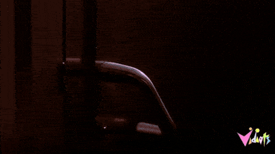 A velociraptor's clawed hand reaching for the kitchen door handle in Jurassic Park