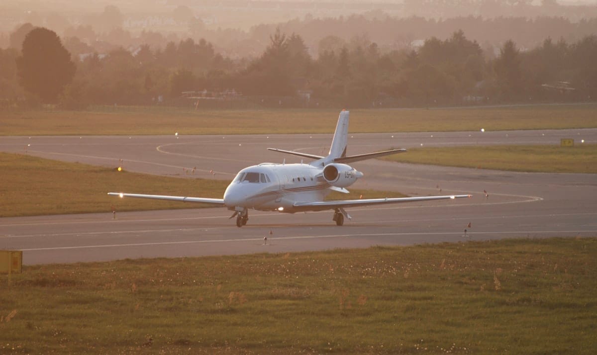 Private jet taxiing on runway at sunset