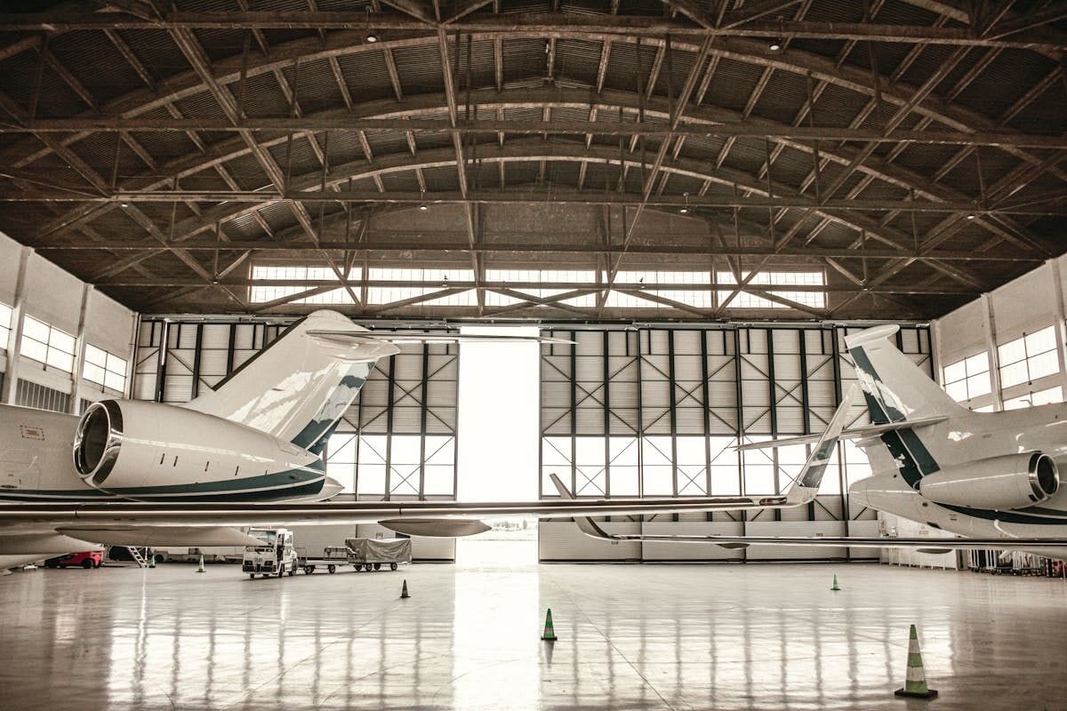 Private jets lined up inside a modern hangar facility